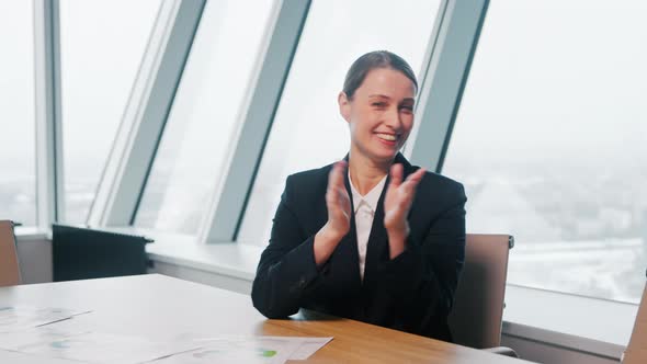 Young girl in a suit discussing via video call in the office