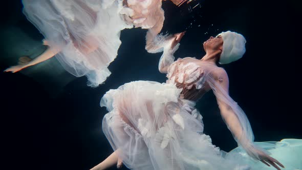 Amazing Undersea Fairy is Floating in Clear Water of Pool or Ocean Beautiful Woman in White Gown