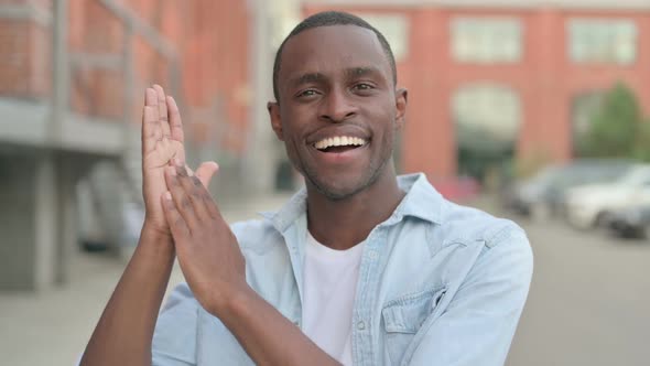 Outdoor Portrait of Happy African Man Clapping Applauding
