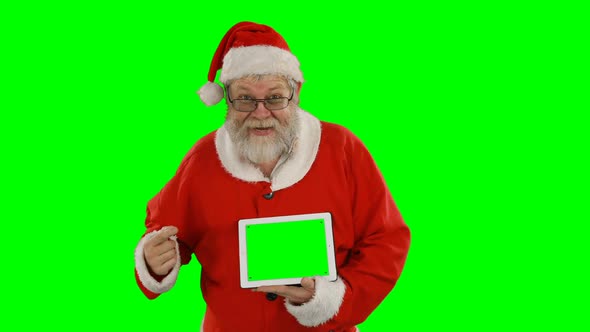 Santa claus holding digital tablet