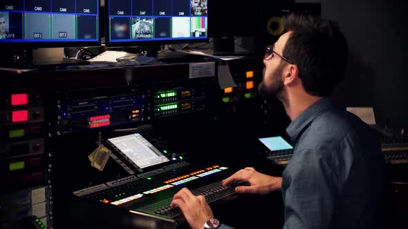 Studio Director On Video Mixer Broadcast TV Station.Operator On TV Channel Studio Room.Sound Control