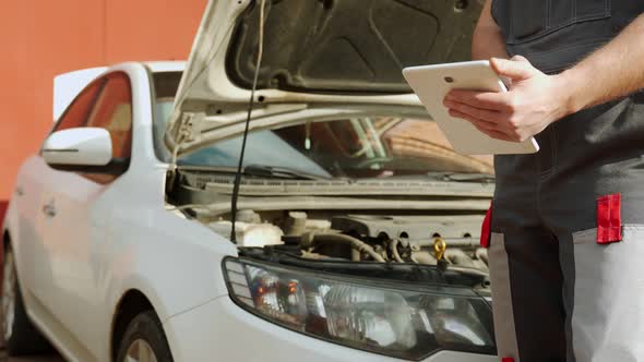 Man Searches Information About Car Repair with Tablet