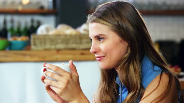 Woman having coffee in cafeteria