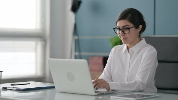 Indian Businesswoman Celebrating Success while using Laptop in Office