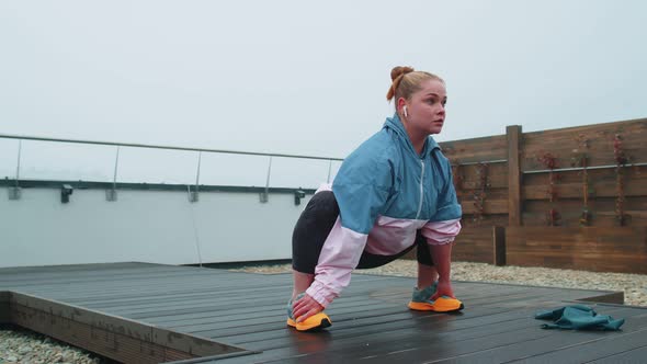 Sporty Fit Woman in Blue Pink Sportswear Doing Squats Yoga Stretching Exercising on Roof of House