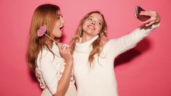 Two beautiful carefree women make funny faces