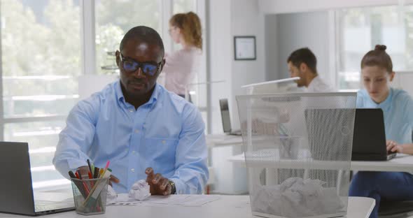 Afroamerican Businessman Throw Crumpled Ball of Paper Into Trash Can in Office