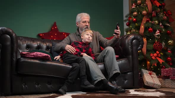 Elegant Old Man and Little Boy Talking on Video Communication on Smartphone