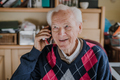 Elderly man talking on phone sitting at home - PhotoDune Item for Sale
