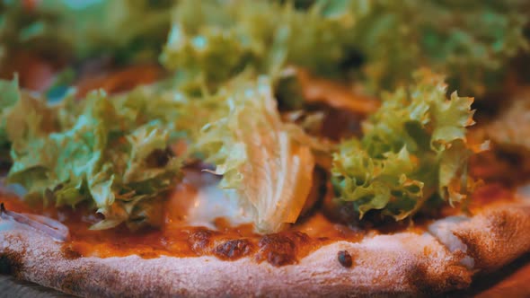 Pizza on a Wooden Tray on a Table in a Restaurant Close-up. Detailed View of Ingredients