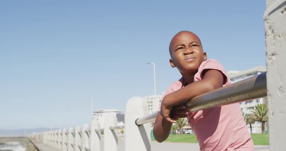 Video of african american boy looking into distance on sunny day