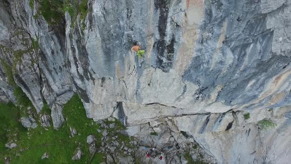 Aerial drone view of a man rock climbing up a mountain