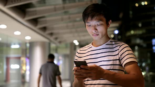 Young man use of mobile phone in the city 