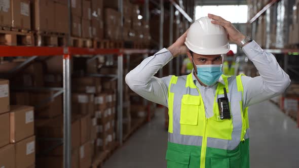Confident Male Putting on Hard Hat in Warehouse