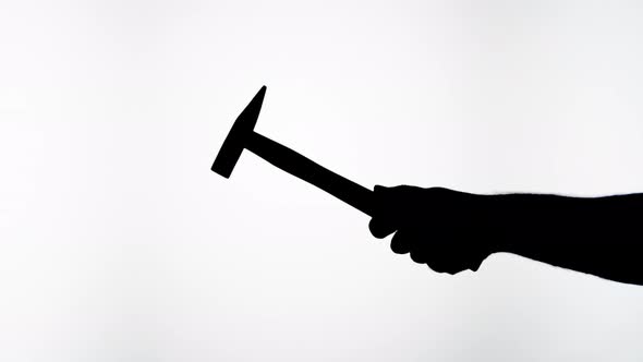 Man Holding Hammer Closeup Shadow Silhouette of Hand with Mallet on White Background