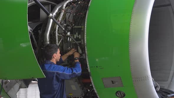 Engine Passenger Aircraft Maintenance. Engineer Checks the Engine of the Aircraft