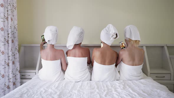 Girlfriends in Towels Make Selfie on Smartphones While Lying on Bed