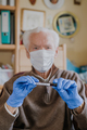 Old man wearing mask, holding Covid-19 sample - PhotoDune Item for Sale