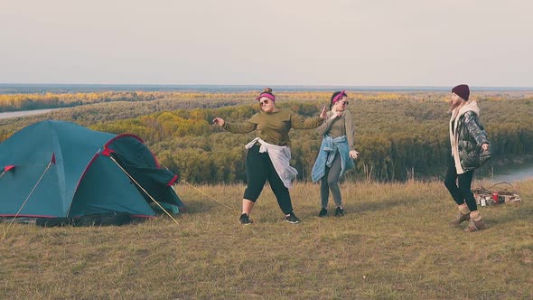 Joyful Women Dance in Camp on Steep River Bank Slow Motion