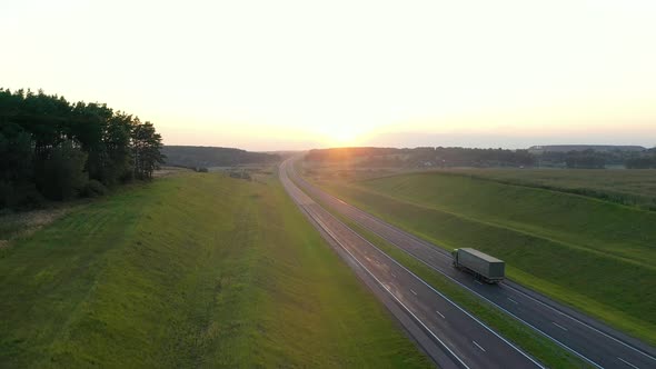 Truck Driver Carrying Cargo On Highway At Sunset Background Aerial View