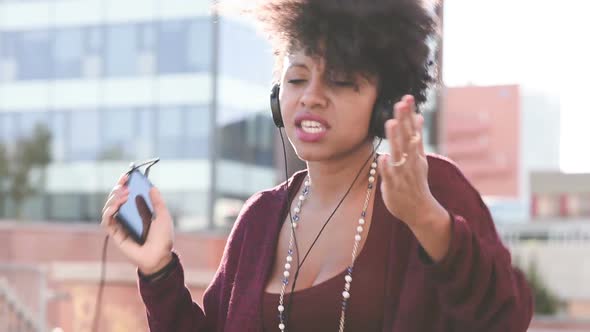 Young black woman dancing singing listening music