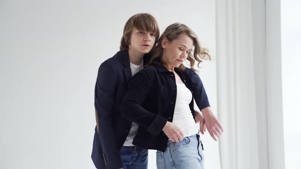 A Mother with Son in Blue Clothes Poses By the Window for a Photo Shoot