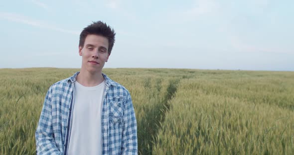 Portrait of Boy Looking at Camera and Crossing Hands with Smile in Field