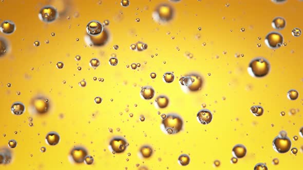 Super Slow Motion Shot of Moving Oil Bubbles on Golden Background at 1000Fps