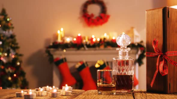 Bottle of whiskey, glass and gift box on wooden table