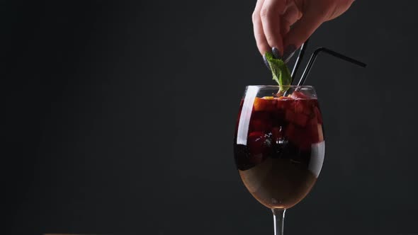 Mulled Wine in a Glass with Straws in Restaurant on Black Background