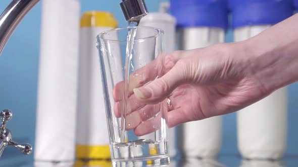 Hand Pouring a Glass of Water From Filter Tap