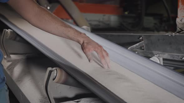 A Working Man Checks the Quality of the Sandclay Mixture