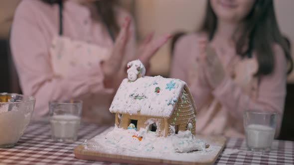 Ginger House with Blurred Unrecognizable Mother and Daughter Clapping Hugging at Background Sitting