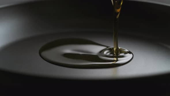 Pouring oil over fry pan. Slow Motion.