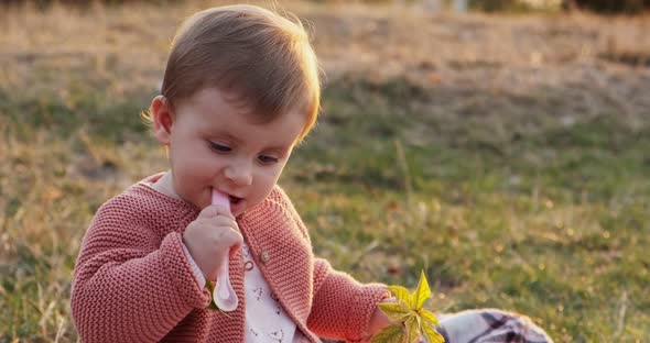 Little Girl Funny Playing in the Park on Green Grass at Fresh Air