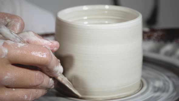 Moulding a clay pot on pottery wheel