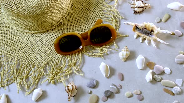 Female straw hat and sunglasses lie on beach sand. Travel summer accessories with  copy space, flat