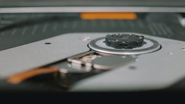 Close-up Shoot of a Person Inserting a CD in a Portable Drive.