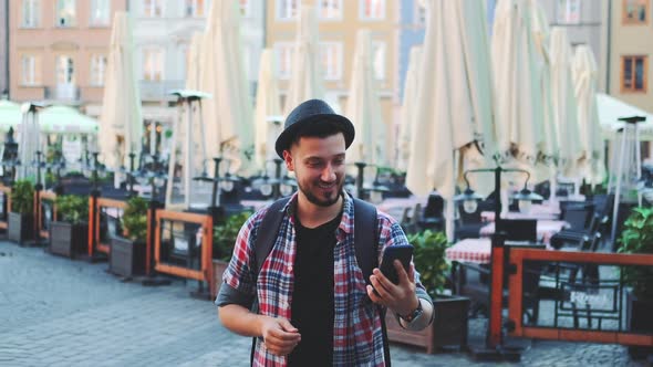 Handsome Tourist Making Video Call on Smartphone and Showing His Place of Visit