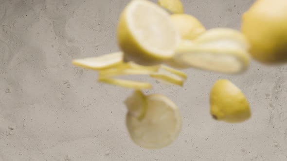 Slow Motion Shot of Flying Fresh Lemon Slices and Crushed on the Sand Commercial