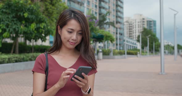 Woman look at smart phone in the street