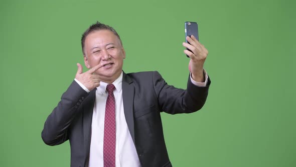 Mature Japanese Businessman Using Phone