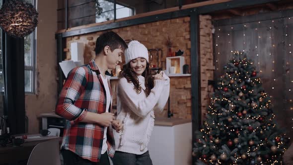 Funny Couple Having Fun at Home in the Living Room Near the Christmas Tree