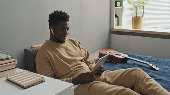 African American Man Video Calling on Tablet in Bedroom