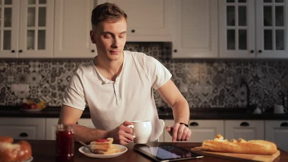 Man Drinking Coffee and Scrolling Tablet