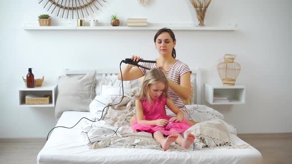 Mother Curling Hair of Her Daughter with Curler