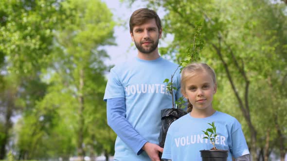 Smiling Father and Daughter Holding Green Plant Saplings Reforestation Fund