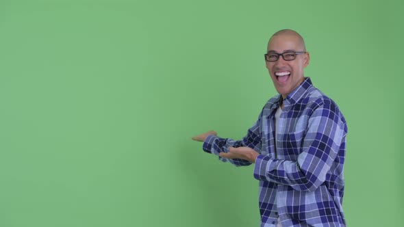 Happy Bald Hipster Man Showing To Back and Looking Surprised