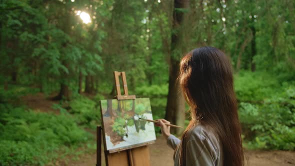 Blackhair Woman Paints a Landscape Oil Painting in Park