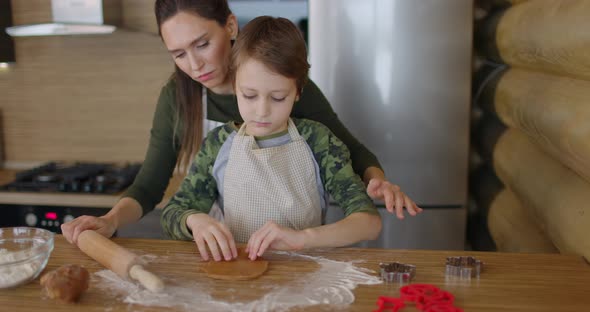 Mother and Son Making Handmade Cookies at Home Rolling Raw Dough Together at Kitchen